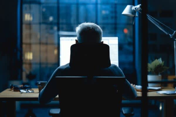 stock photo of a person sitting at a computer at night